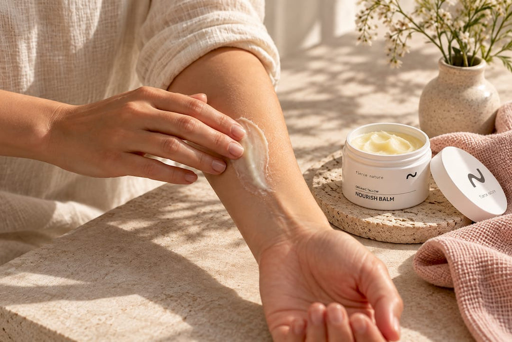 Hands applying balm to dry forearm
